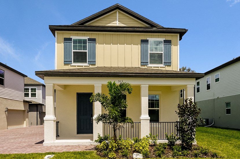 a yellow house with a black door and a porch