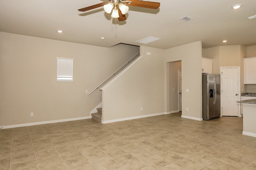 the spacious eat in kitchen with stainless steel appliances and a ceiling fan