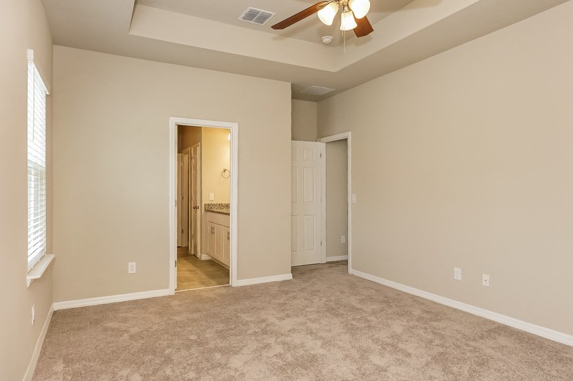 an empty living room with a ceiling fan