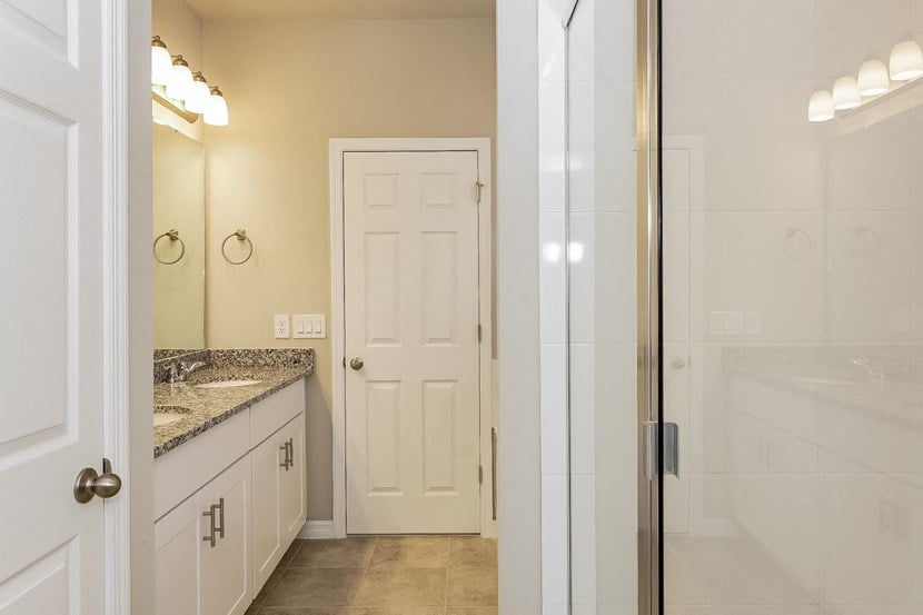 a bathroom with a shower and a sink and a door