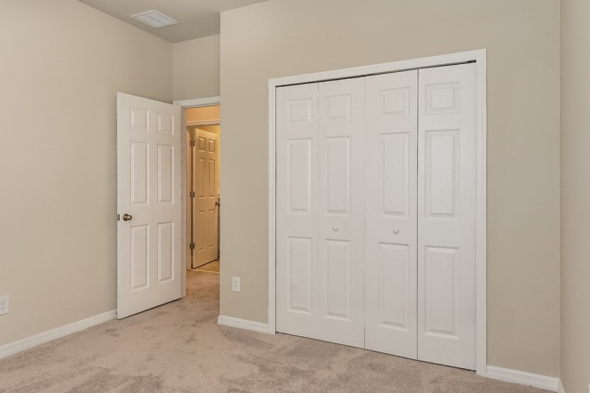 a bedroom with two closets and a door to a hallway