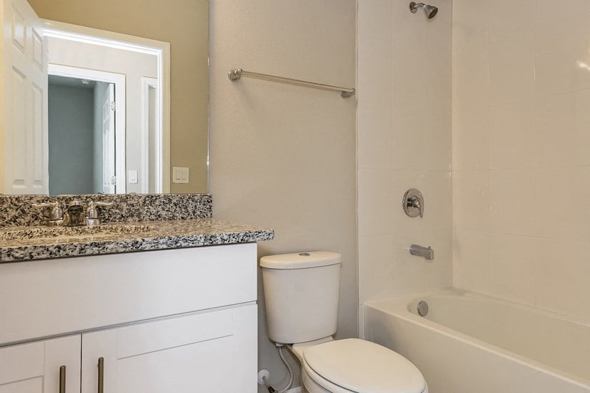 a bathroom with a toilet and a tub and a sink