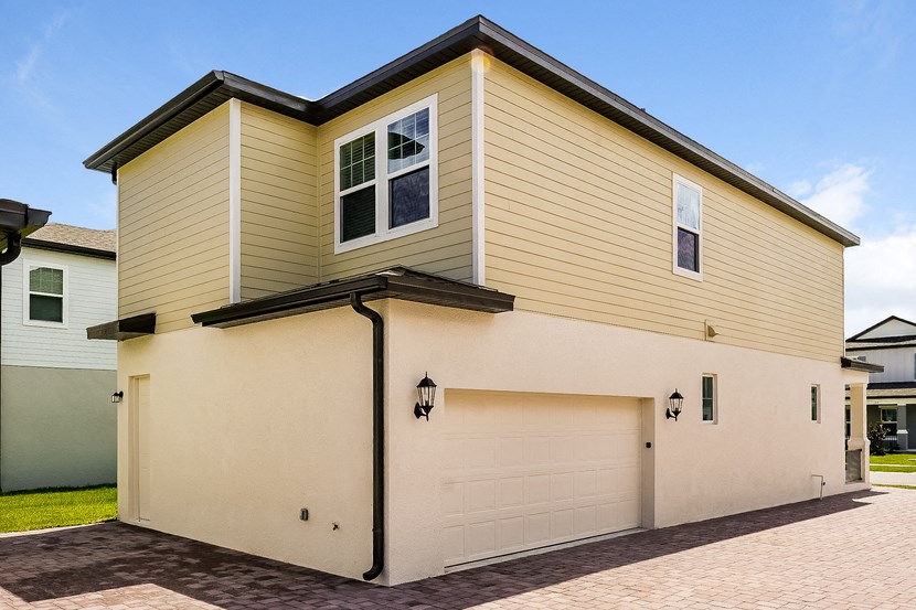 a white and yellow house with a garage door
