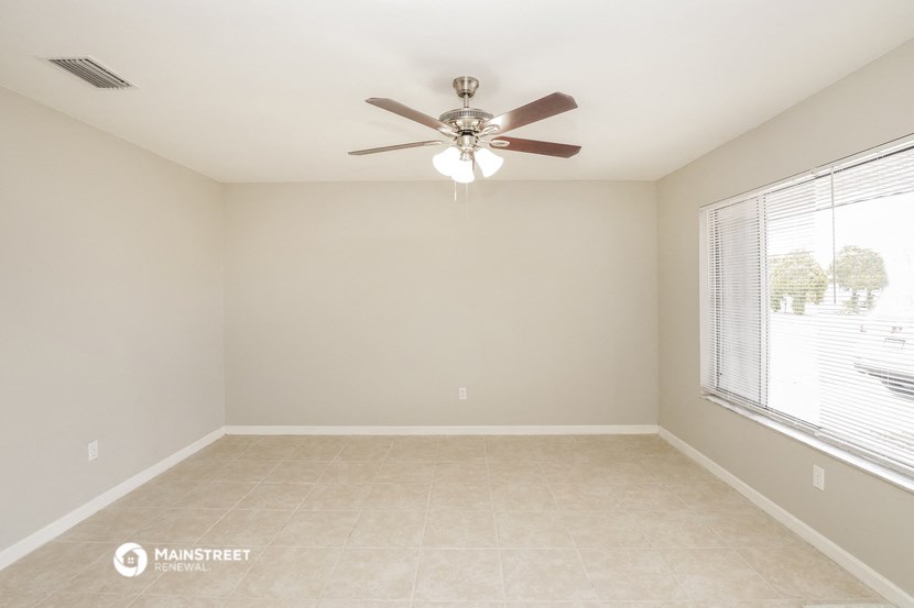 an empty room with a ceiling fan and a large window