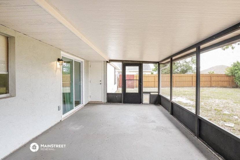 a large empty room with glass doors and a patio