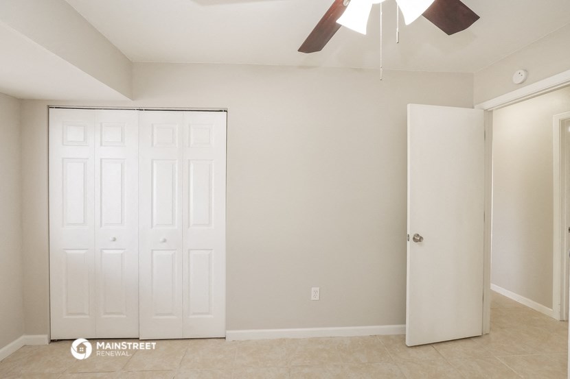 a bedroom with two closets and a ceiling fan