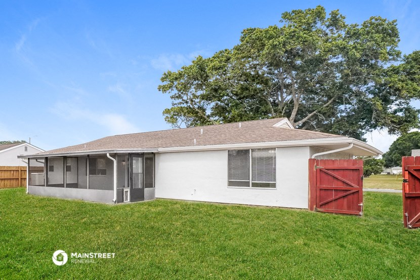 a small white house with a red garage door