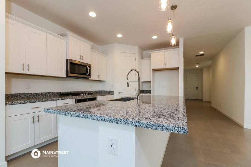 a kitchen with white cabinets and a granite counter top