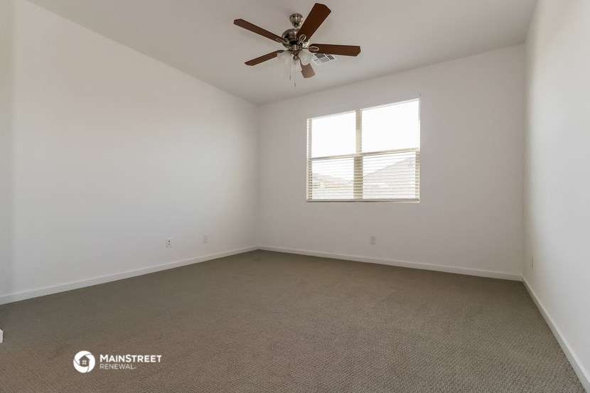 a living room with a ceiling fan and a window