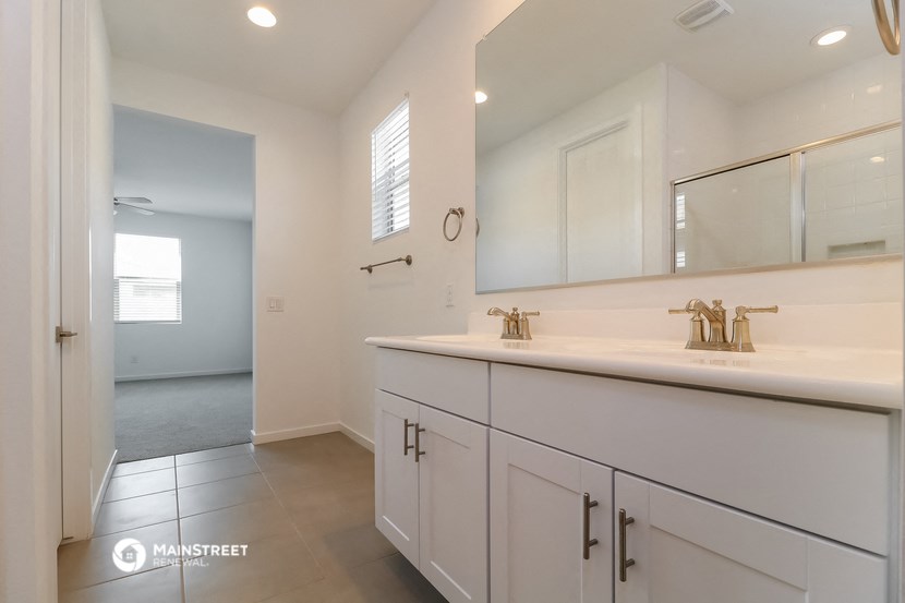 a bathroom with white cabinets and a sink and a mirror