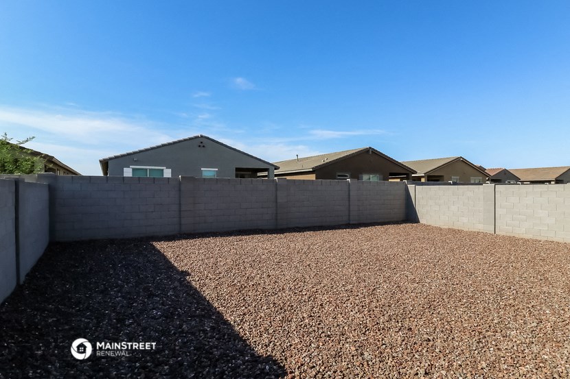 a backyard with a fence and houses in the background