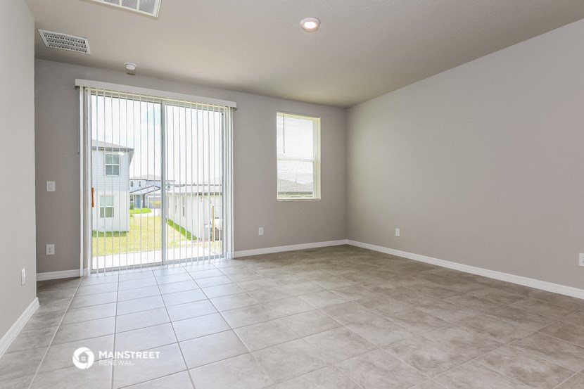 the living room of an empty house with a patio door