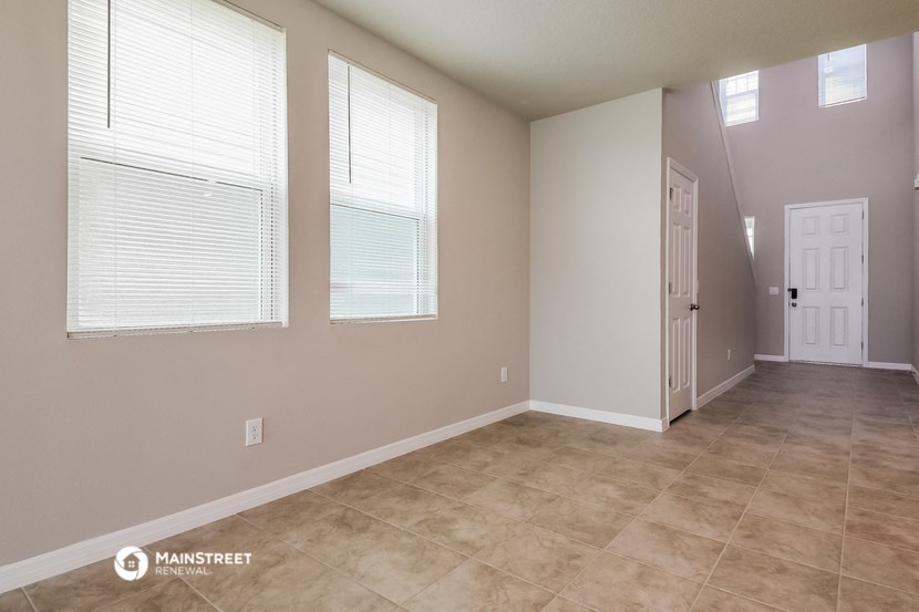 the spacious living room with a door to the hallway