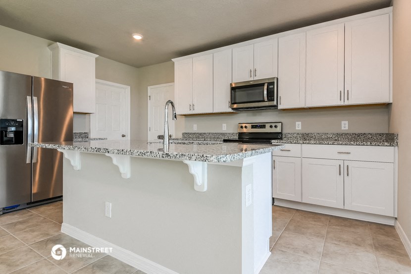 a kitchen with white cabinets and a granite counter top