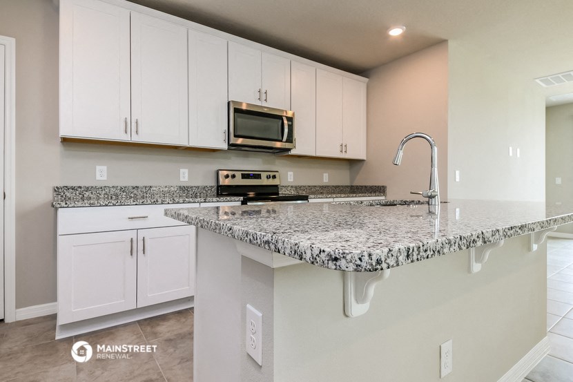a kitchen with white cabinets and a granite counter top