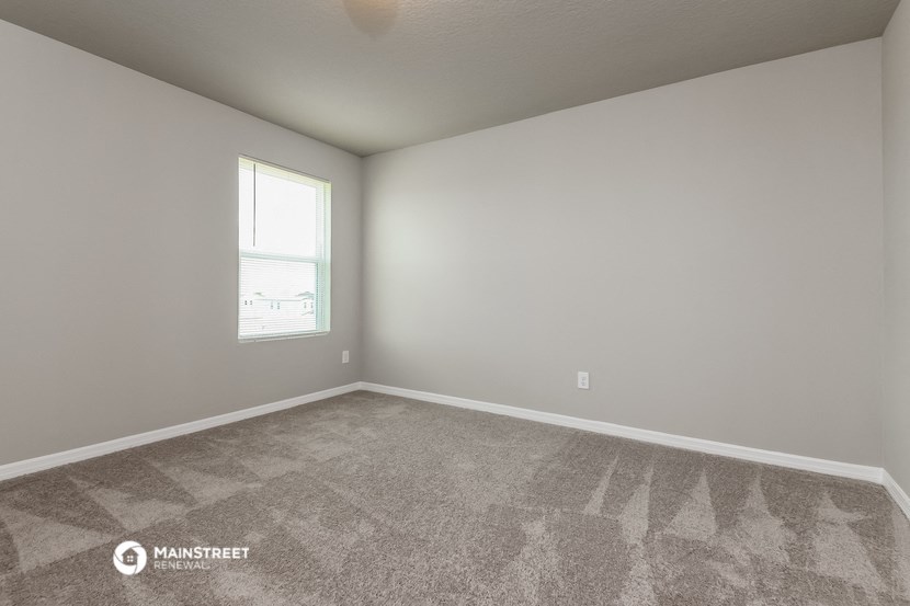 an empty room with carpet and a window