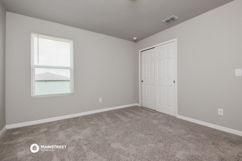 the bedroom of a house with carpet and a white door