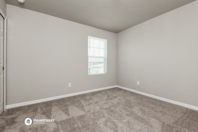 an empty room with carpet and a window