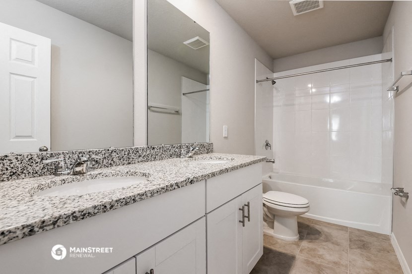 a bathroom with two sinks and a toilet and a shower