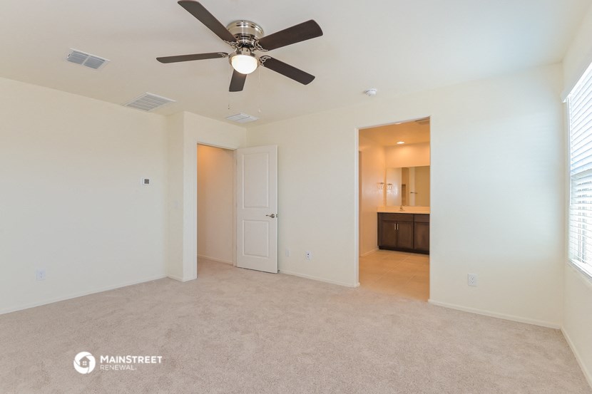 an empty living room with a ceiling fan