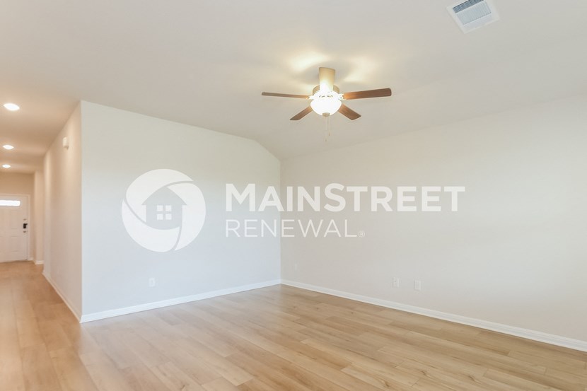renovated living room with hardwood flooring and a ceiling fan