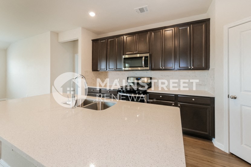 a kitchen with white countertops and black cabinets