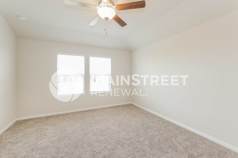 a bedroom with carpet and a ceiling fan