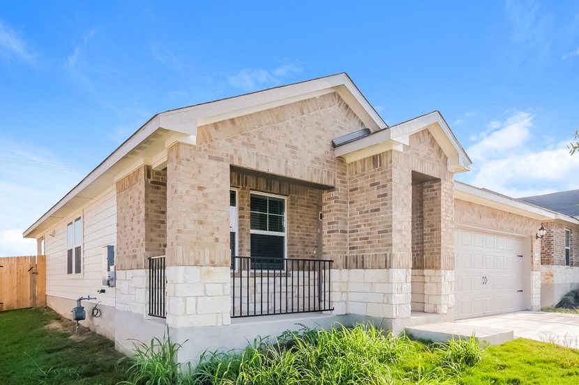 the front of a brick house with a white garage door