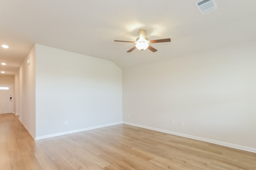 a living room with white walls and a ceiling fan