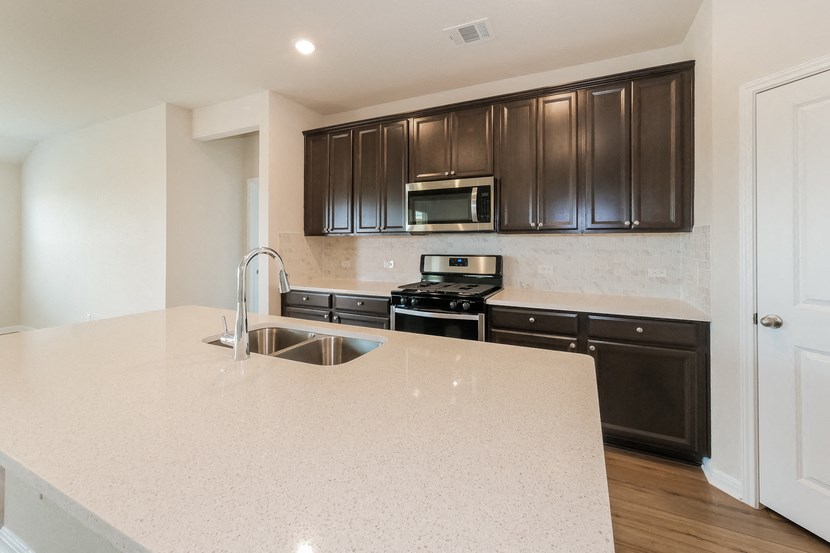 a kitchen with black cabinets and a white counter top