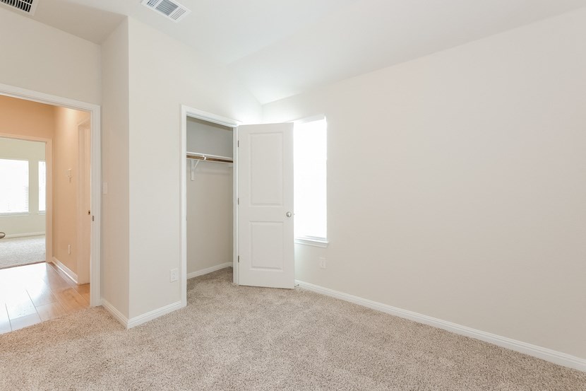 an empty bedroom with a closet and a window