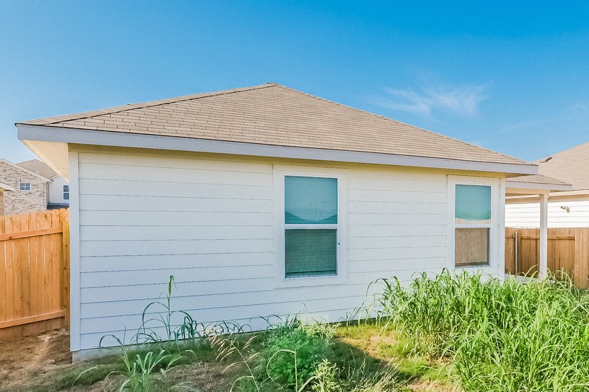 a small white house with grass in front of it
