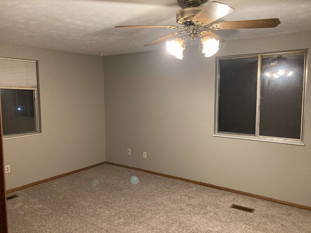 a bedroom with a ceiling fan and a window