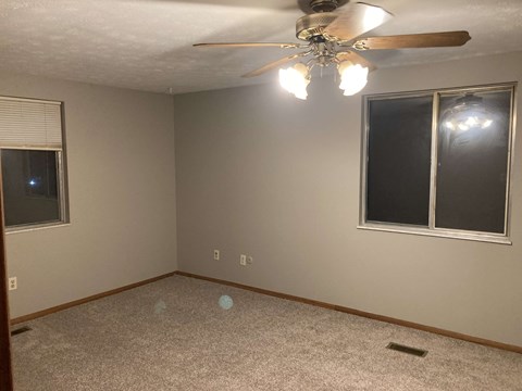 a bedroom with a ceiling fan and a window