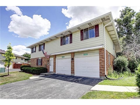 a white and brick house with two garage doors