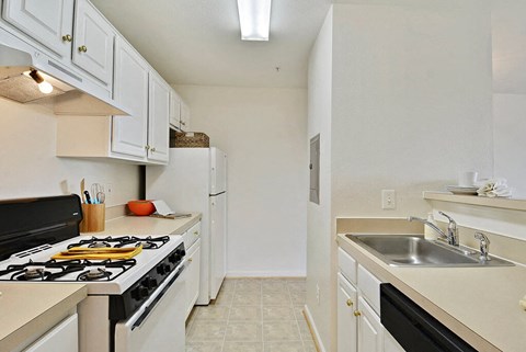 a kitchen with white cabinets and a stove and a sink