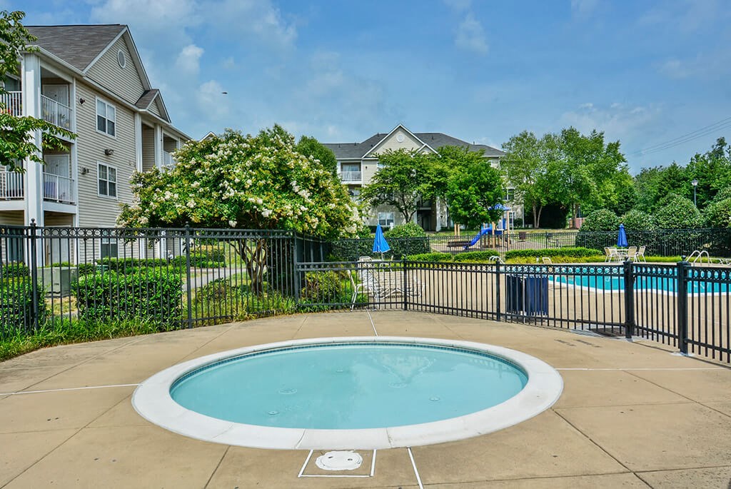 a round swimming pool in a fenced in yard with houses