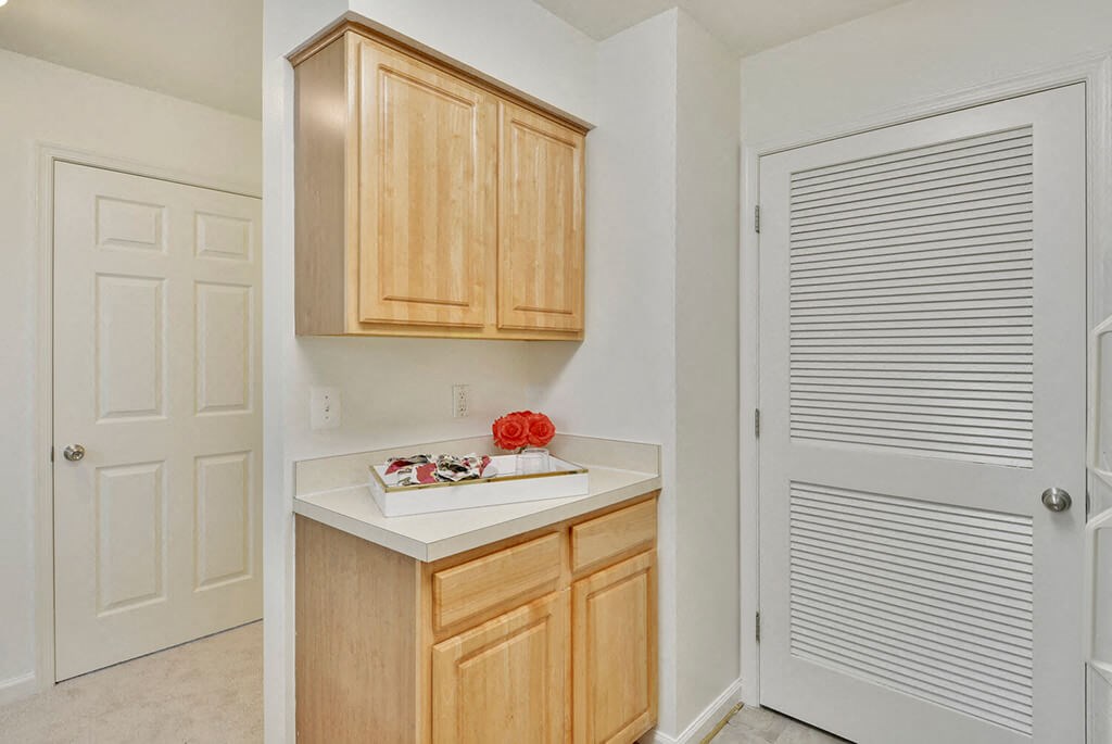 a kitchen with wooden cabinets and a white door