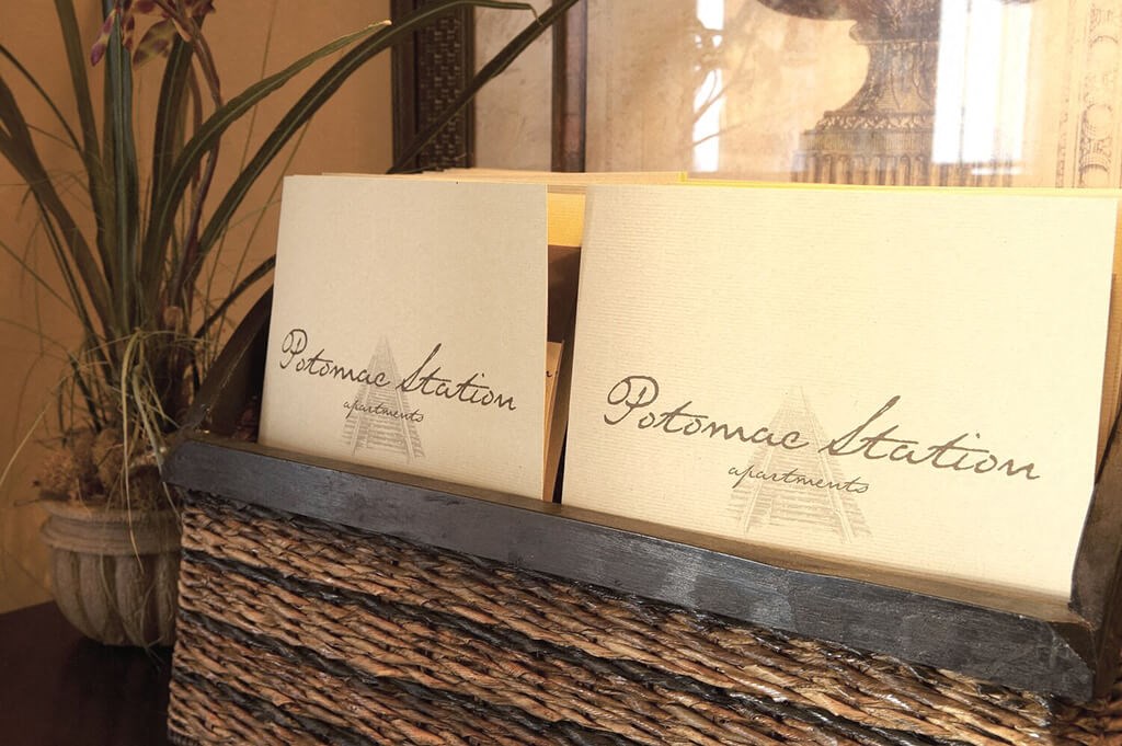 two boxes of perfume sitting on a table next to a plant