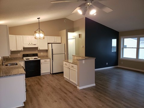 a kitchen with white cabinets and a black wall