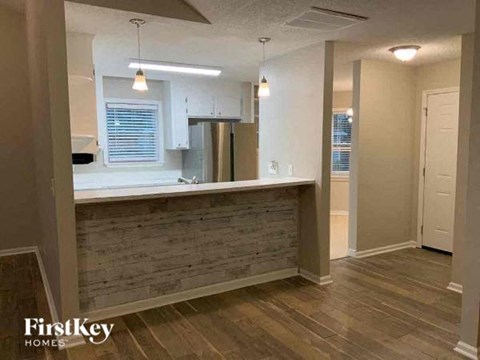 A kitchen area with a wooden counter and a refrigerator.