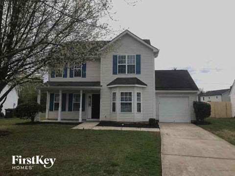 a white house with a sidewalk in front of it