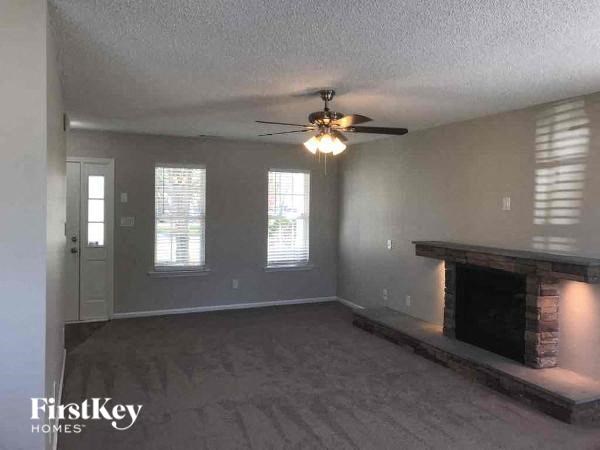 a living room with a fireplace and a ceiling fan