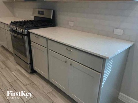 A kitchen with a stove top oven and a counter top.