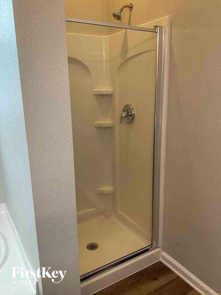 a walk in shower in a bathroom with the door open