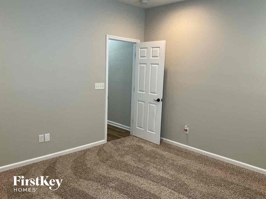 an empty room with a door open to a closet