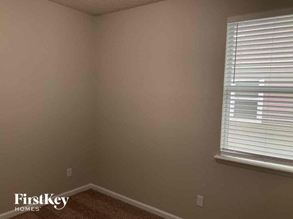 a corner of a room with a window and blinds