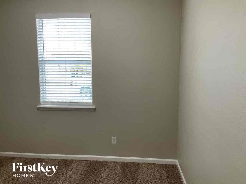 an empty room with a window and a carpet