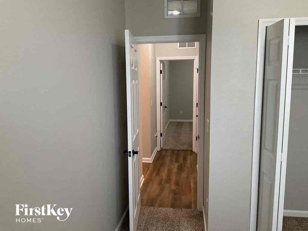 a small hallway with a door open to a bedroom and a hallway to a bathroom