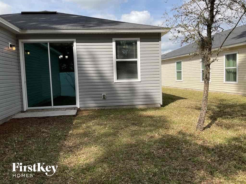 the front of a house with a yard and a tree
